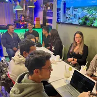 La mesa larga, con portátiles abiertos y varias personas hablando al tiempo.