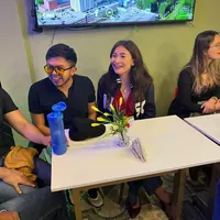 Dos asistentes riéndose en medio de la conversación.