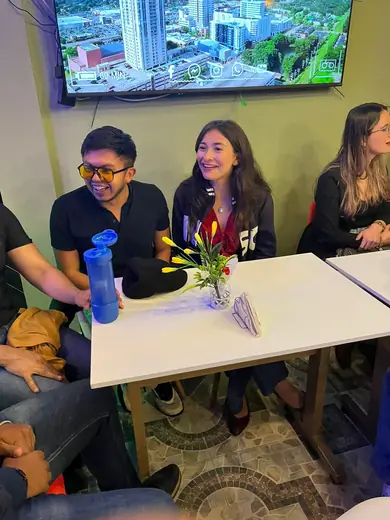 Tres asistentes riéndose en medio de la conversación.