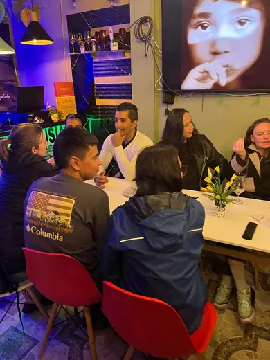 Gente de espaldas y de frente conversando en el salón.